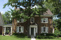 Front Of Beautiful Brick Home With White Window Trim