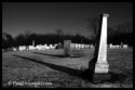 Single Monument With Line Of Tombstones Behind